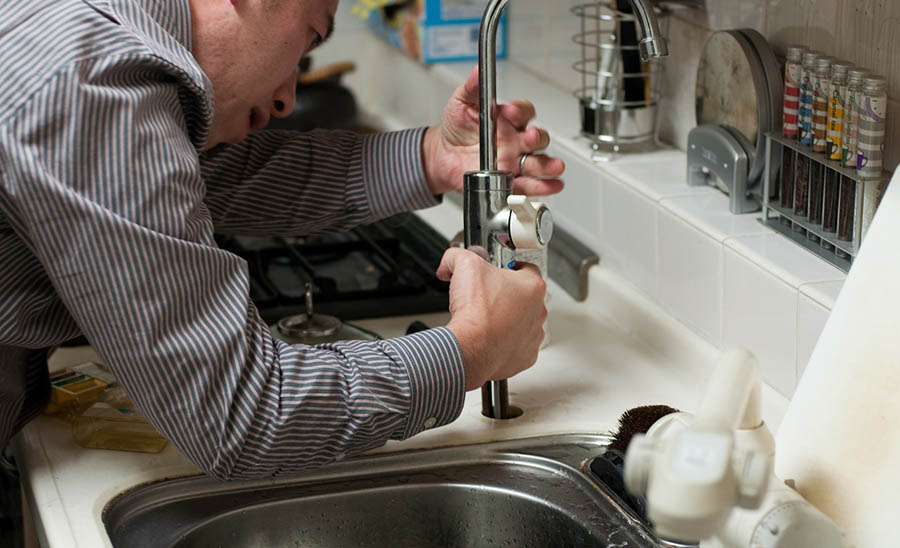 Man tries to install a new sink faucet