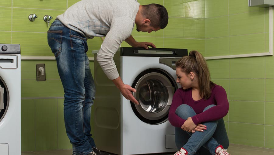 Man showing women how to use front loading washer