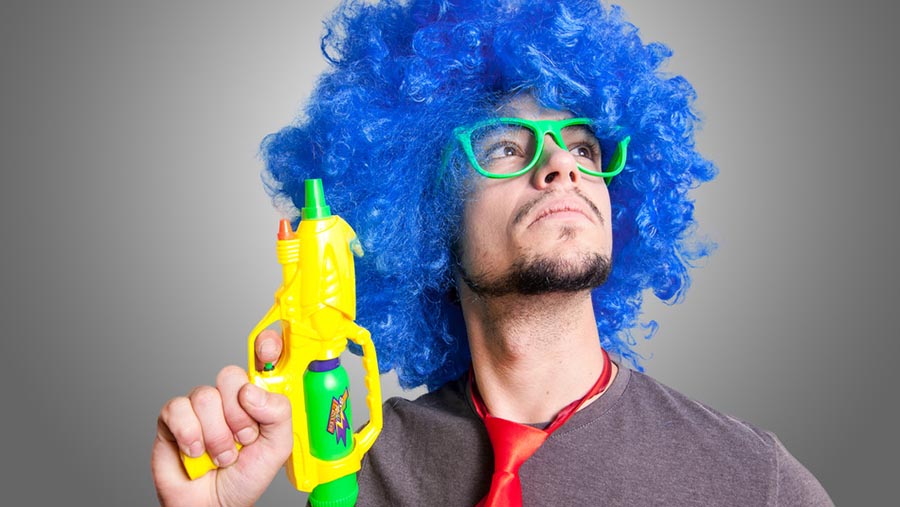 Man with blue afro, green sunglasses and a water gun