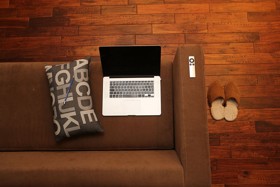 Laptop and other personal belongings on a brown couch