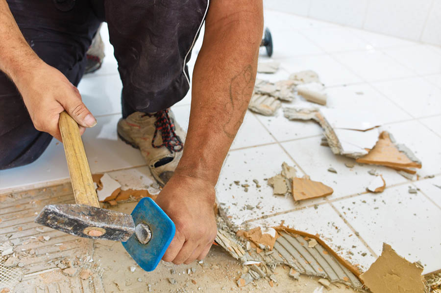 Person hammers a floor with a tool