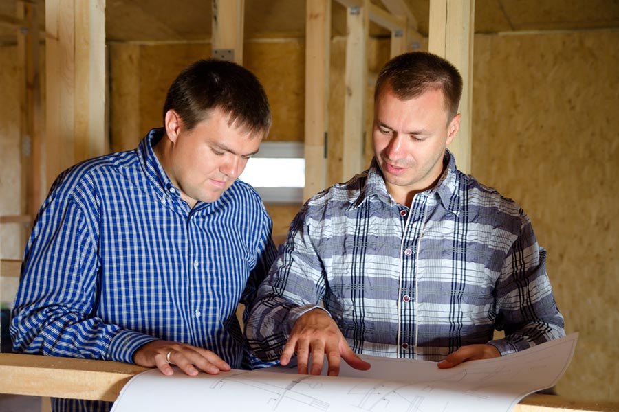 Two men reviewing house construction and renovation plans