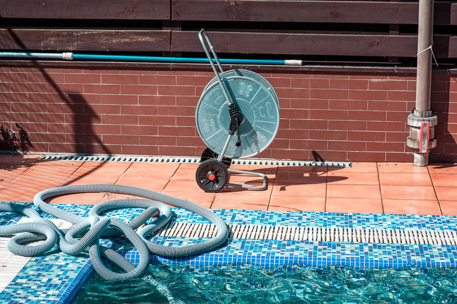 Inground pool with maintenance equipment beside it