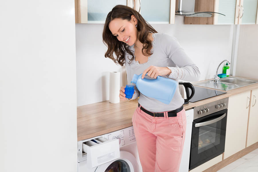 Women pouring dishsoap into her front loading washer