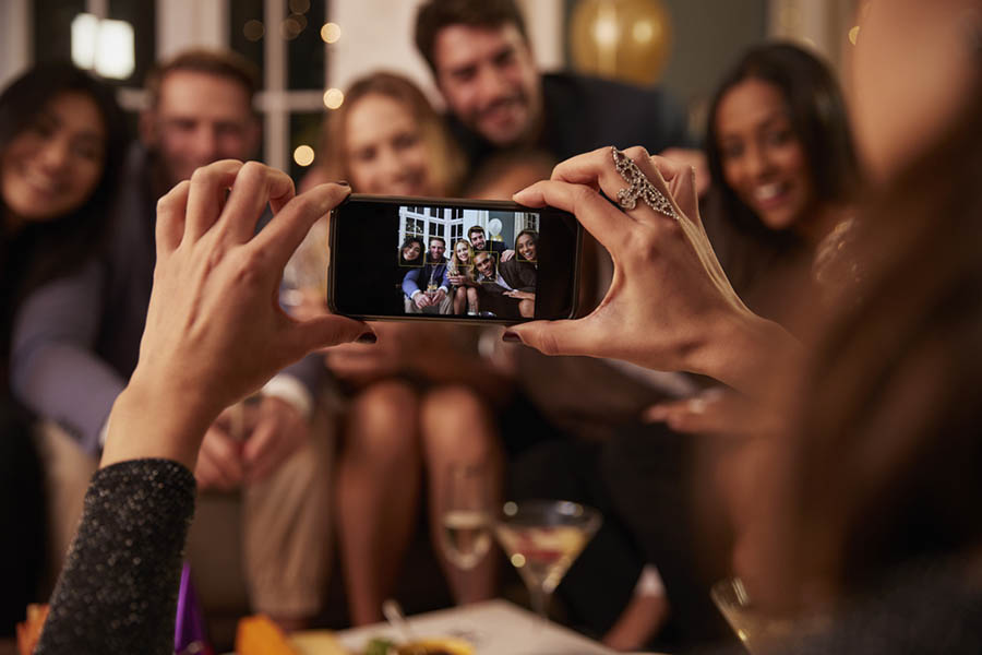 Holiday party host taking a picture of the party guests