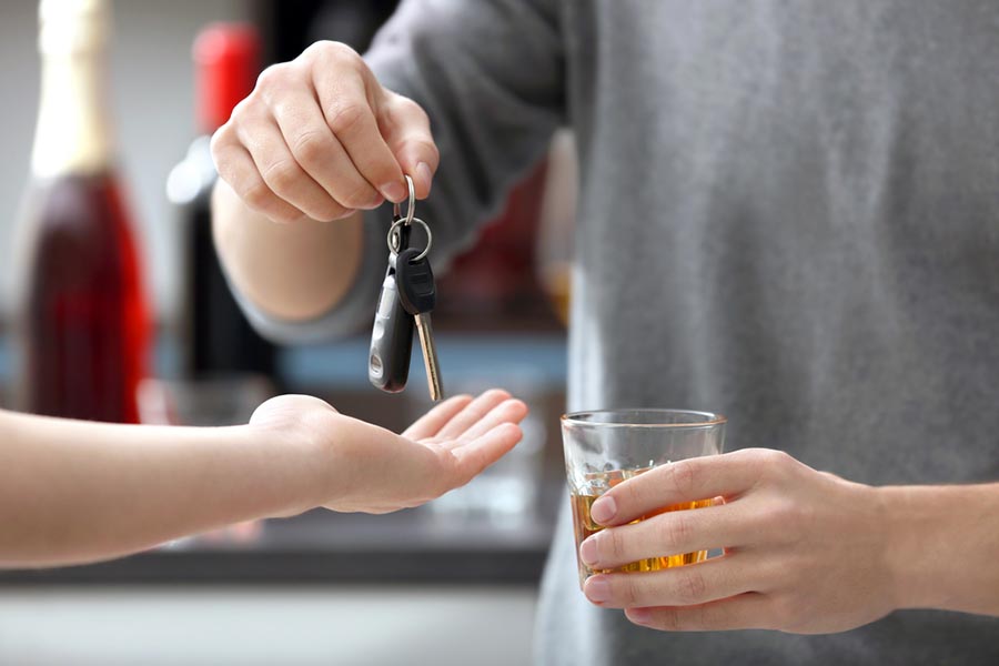 Person giving his keys to someone while they drink alcohol