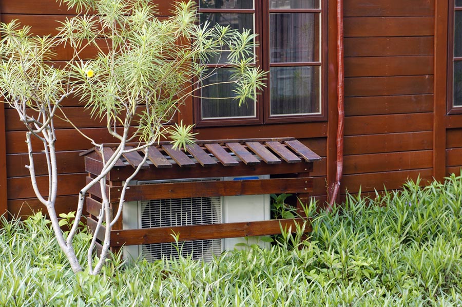 HVAC system enclosed in a custom wood frame, protected from weather and rodents