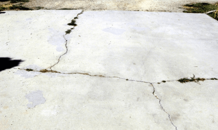 Concrete driveway that has cracks running through it