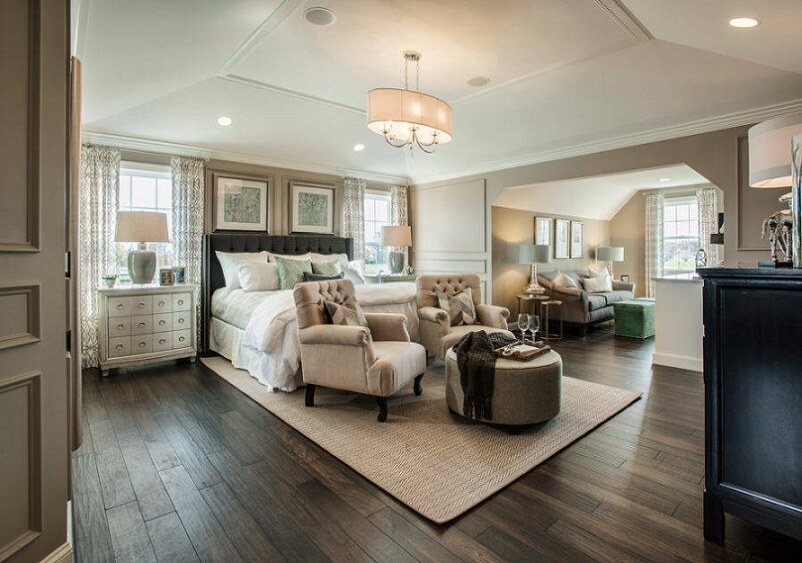 Master bedroom with light furniture and dark floors