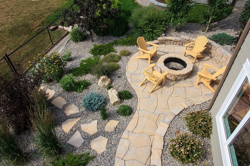 Aerial view of a stone patio with a fireplace and seating