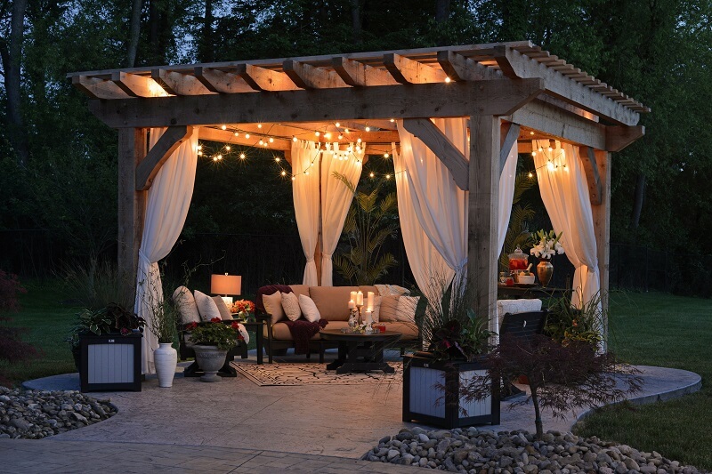 Gazeebo and patio space with hanging lights at night