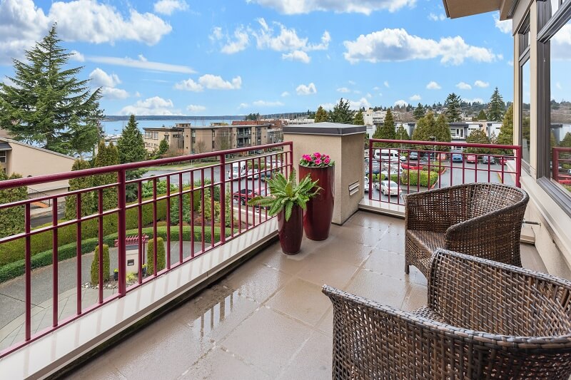 Small apartment patio with brown wicker chairs for seating