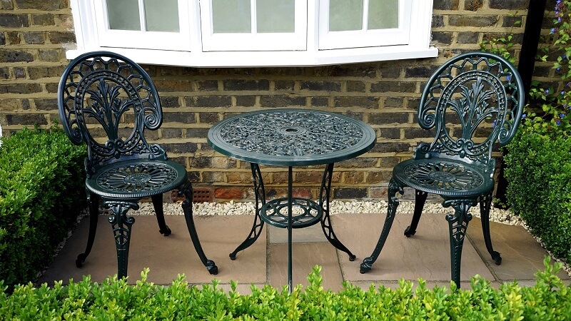 Tiny outdoor area with wrought iron chairs and table