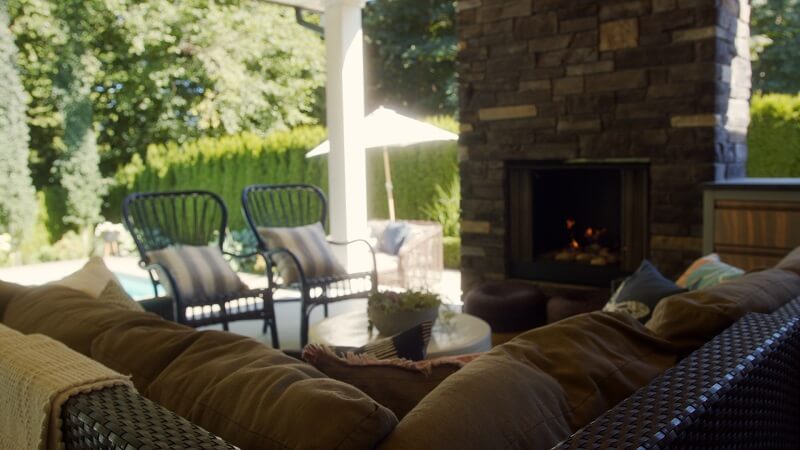 Wicker and aluminum patio furniture by a stone fireplace