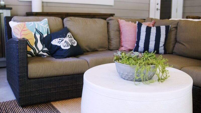 Outdoor couch and throw pillows near a table