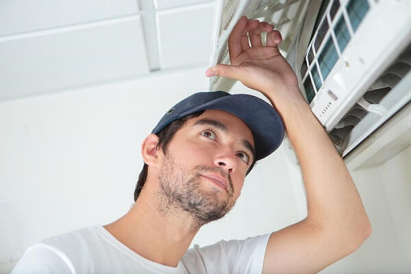 Repair man inspecting the air conditioner