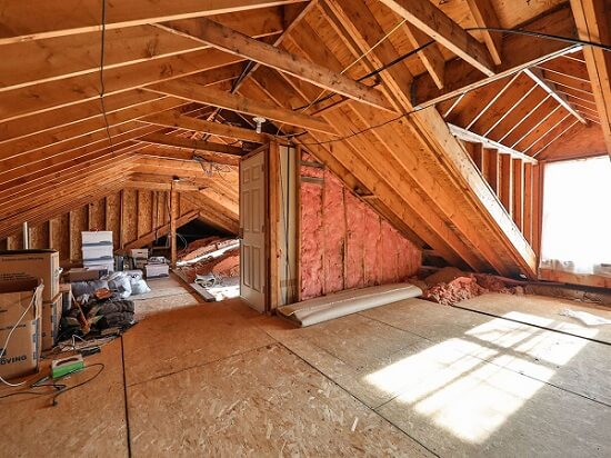 Unfinished home attic with exposed insulation