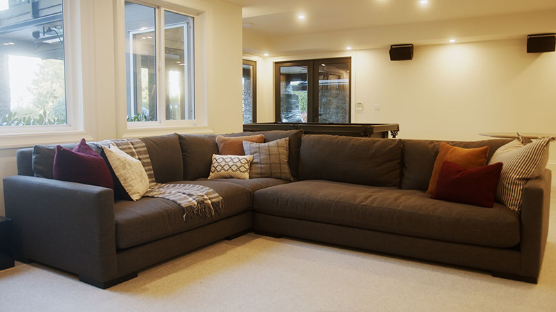 Several cushions arranged on an L-shaped sectional sofa