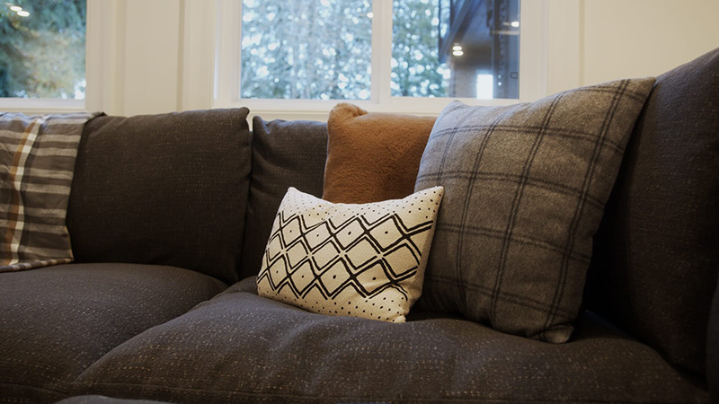 Three pillows arranged on a dark sofa