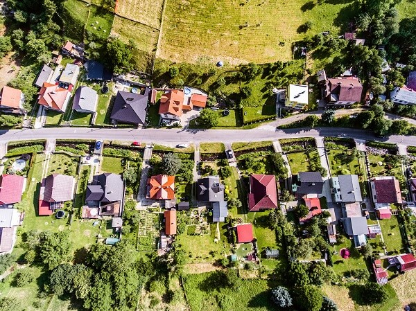 Overhead view of a neighbourhood surrounded by trees and fields