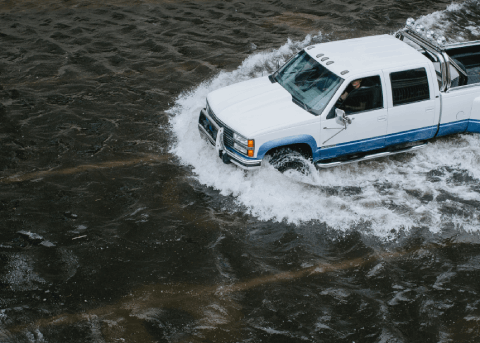 Un camion passe à travers une route inondée