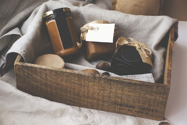 A wooden box with jars inside, used as an Airbnb gift basket