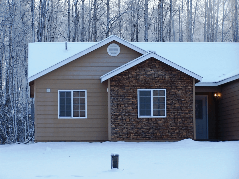 Une maison couverte de neige et revêtue du bardage de brique