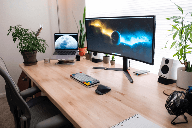 Image d’un espace de télétravail avec portable, moniteur et d’autre équipement technique sur un bureau