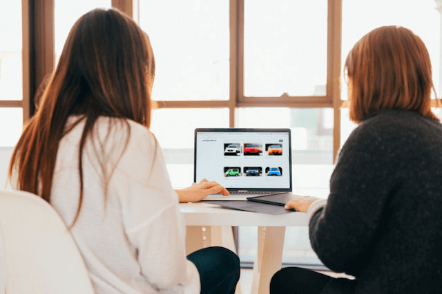 Two women purchasing car insurance on their computer