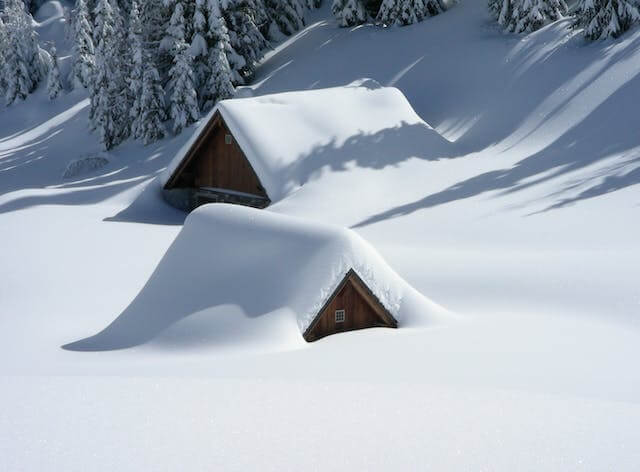 Two buildings covered with snow