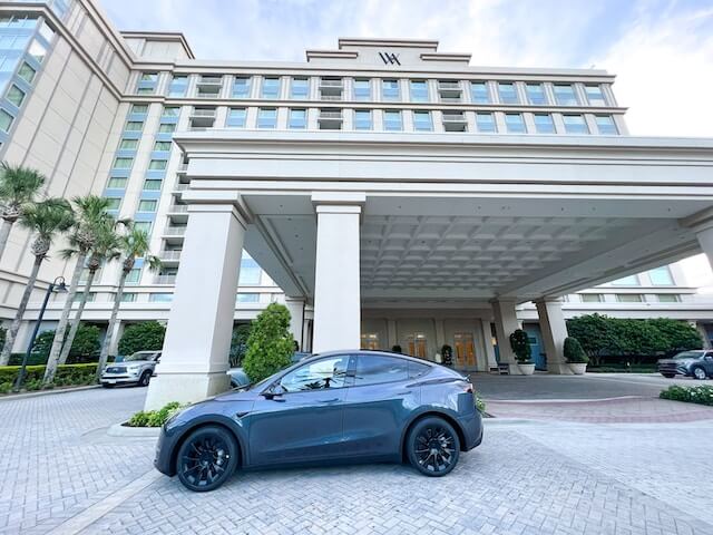 A grey rental sedan parked in front of a hotel