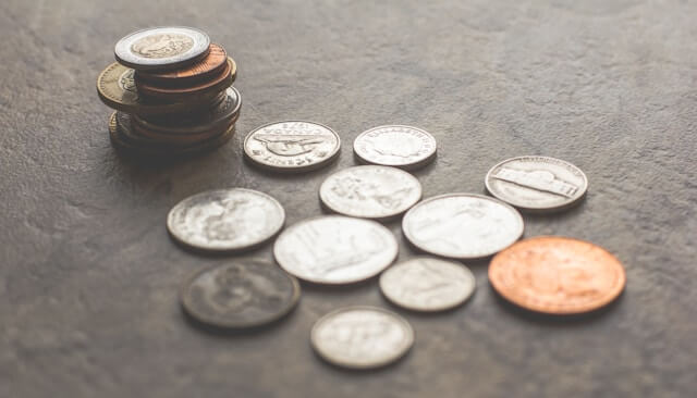 A small collection of coins sitting on a grey surface